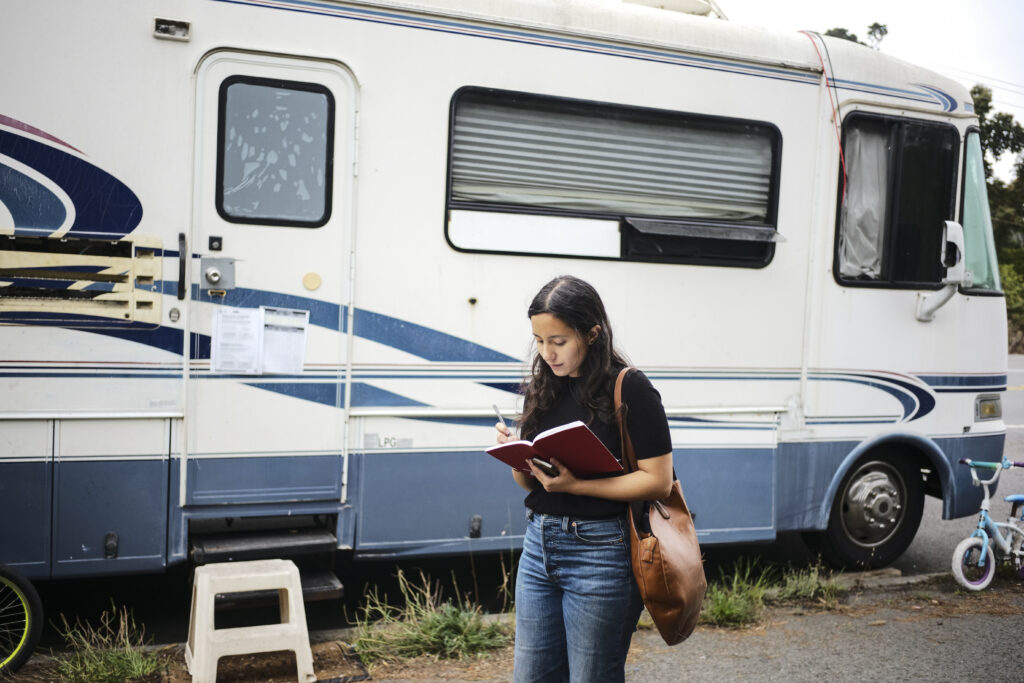 Mariana Duran takes notes in her journal for a report about RV displacement in the Lake Merced neighborhood in San Francisco, Calif., on Sept. 24, 2025. Photo: Pablo Unzueta for El Tecolote/CatchLight Local