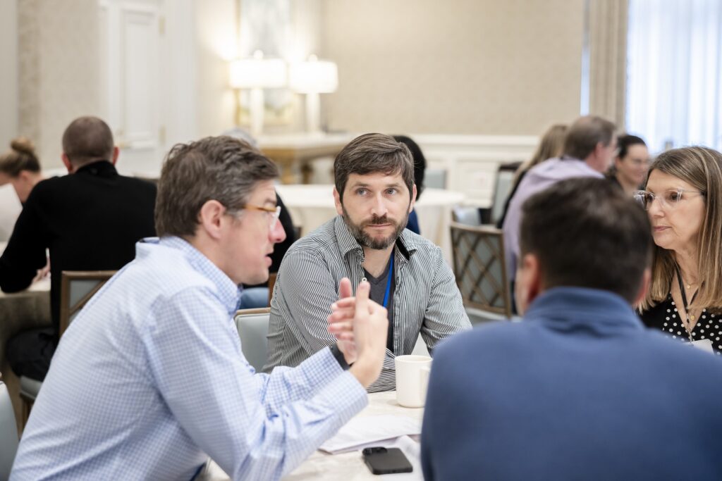 Liam Andrew (center) of American Journalism Project, in conversation at the AJPalooza conference in New Orleans. (Photo by Kathy Anderson Photography for AJP)